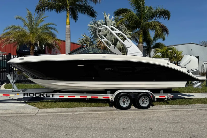 The Image of 2019 Sea Ray SDX 270 Outboard boat on trailer, surrounded by palm trees. - 1