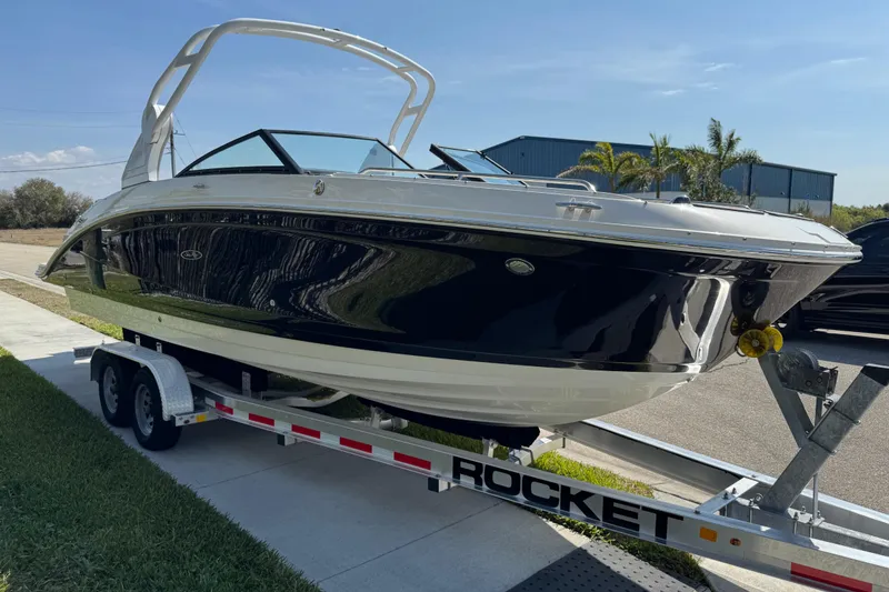 Slide: The Image of 2019 Sea Ray SDX 270 Outboard boat on a trailer, parked outdoors. - 12