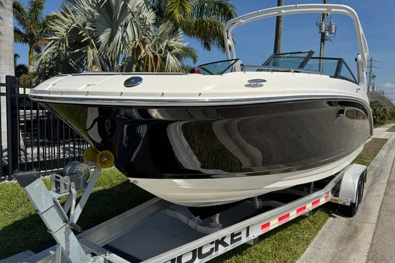 Slide: The Image of 2019 Sea Ray SDX 270 Outboard boat on trailer, parked near palm trees. - 14