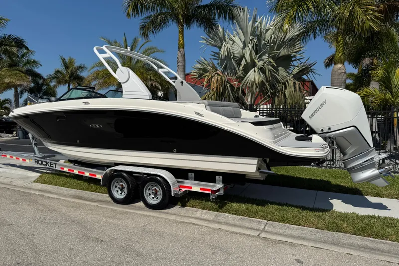 Slide: The Image of 2019 Sea Ray SDX 270 Outboard boat on trailer, surrounded by palm trees. - 3