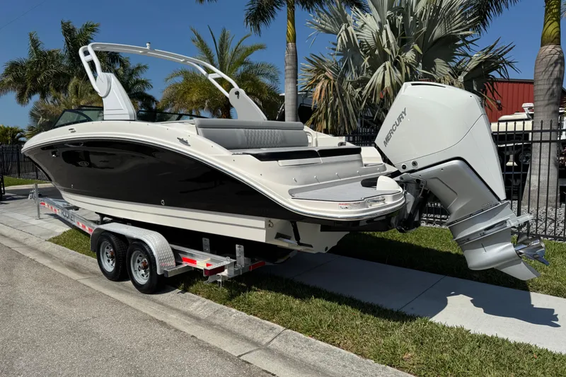 Slide: The Image of 2019 Sea Ray SDX 270 Outboard boat on trailer, parked near palm trees. - 4