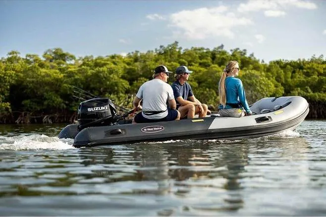 Slide: The Image of 2023 West Marine MH400 inflatable boat with three passengers cruising on a calm waterway. - 6