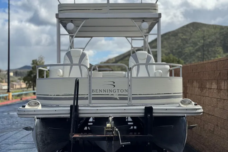Slide: The Image of 2006 Bennington 2875RLTD I/O pontoon boat on trailer, scenic mountain backdrop. - 2
