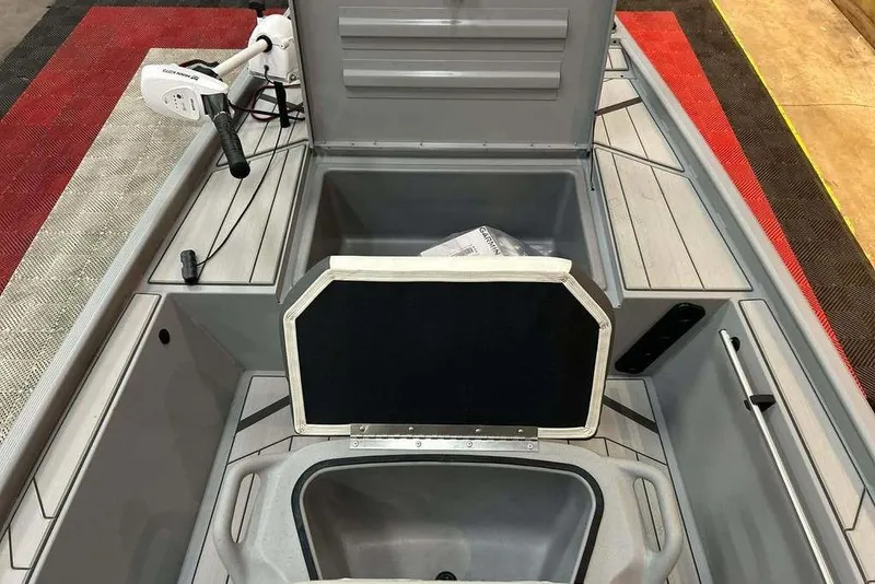 Slide: The Image of 2026 Tracker Bass Tracker Classic CC boat interior with storage compartments and trolling motor. - 11
