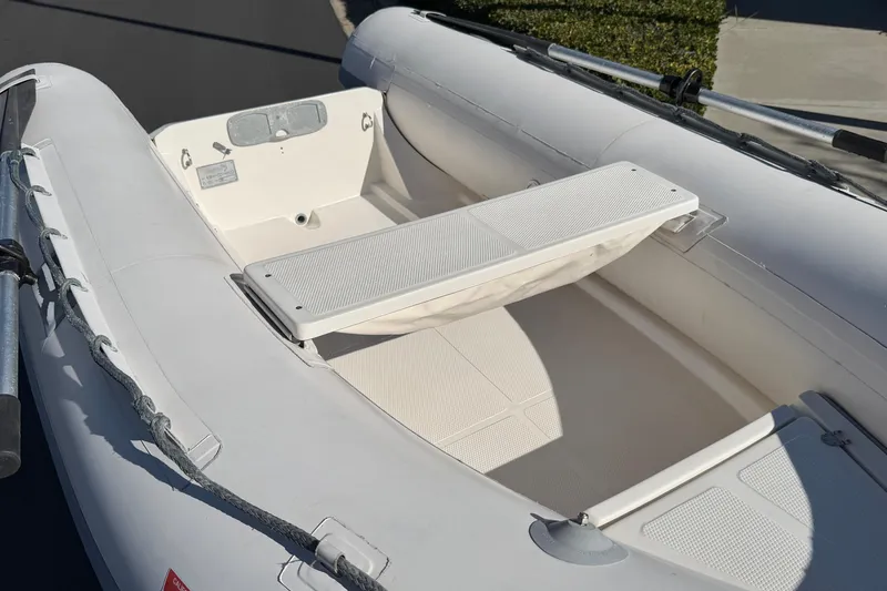 Slide: The Image of Inflatable boat interior, Caribe C10X 1999 model, featuring seating and oar holders. - 2