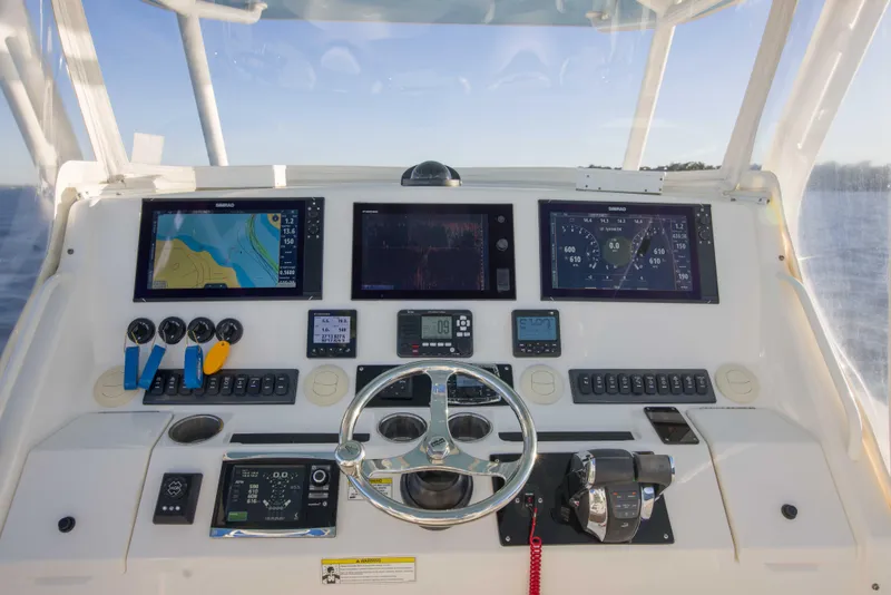 Slide: The Image of Control panel of a 2016 Regulator 41 boat with navigation screens and steering wheel. - 16