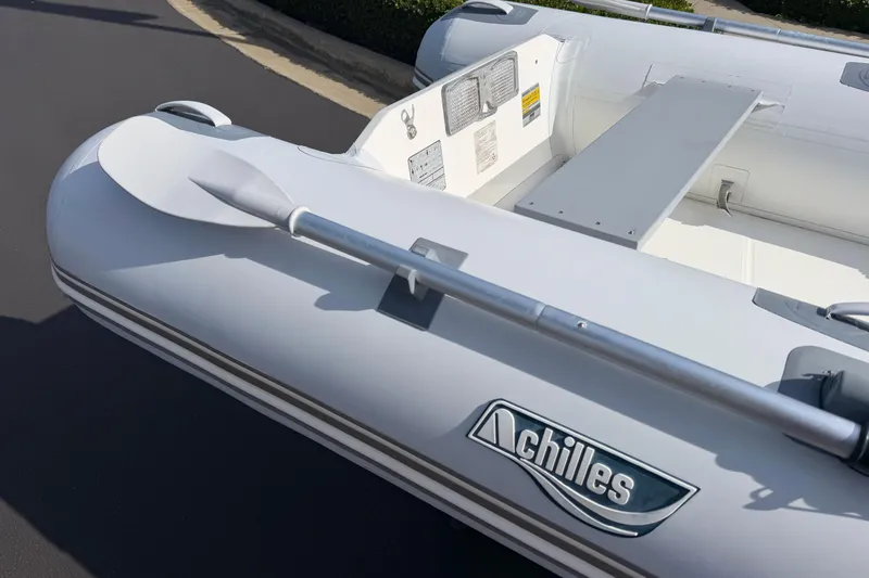 Slide: The Image of Inflatable Achilles HB-300FX boat, 2012 model, with oar and branding visible. - 11