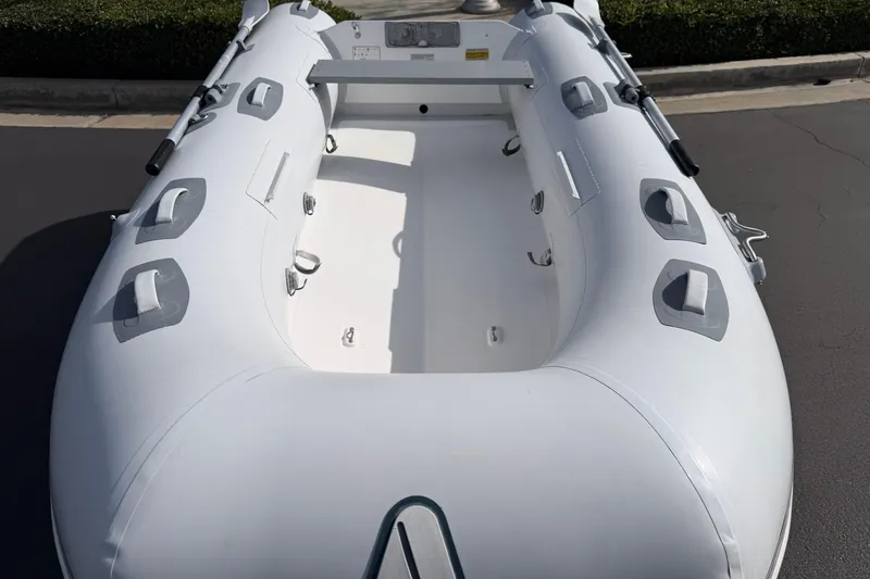 Slide: The Image of Inflatable Achilles HB-300FX boat, 2012 model, white with gray accents, docked outdoors. - 12