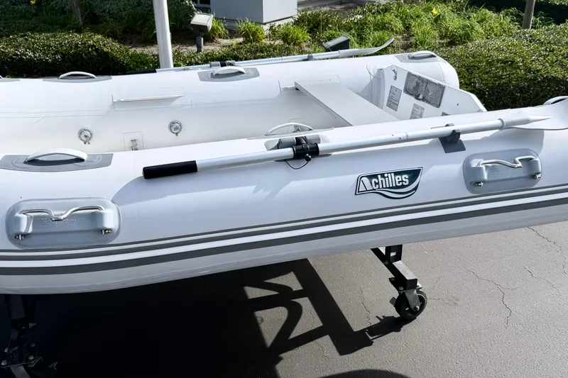 Slide: The Image of Inflatable Achilles HB-300FX boat, 2012 model, on a wheeled stand outdoors. - 3