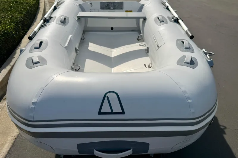 Slide: The Image of Inflatable Achilles HB-300FX boat, 2012 model, on pavement with oars attached. - 5