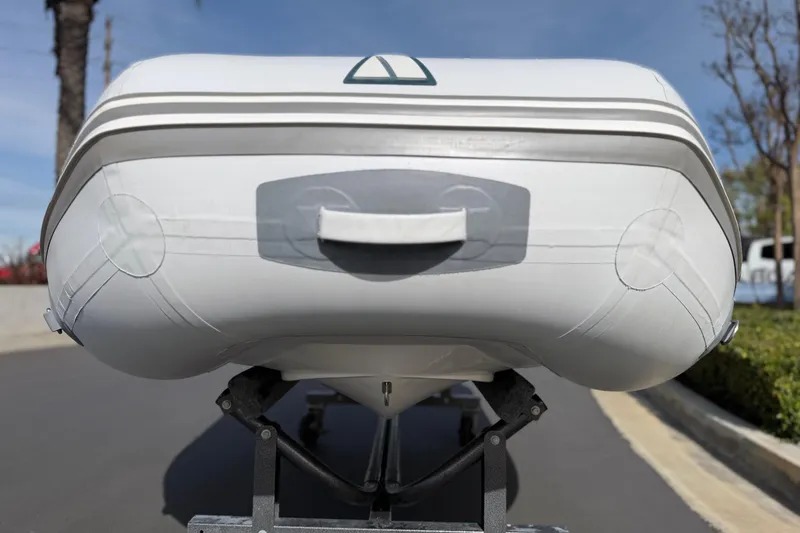 Slide: The Image of Inflatable Achilles HB-300FX boat, 2012 model, on a trailer under clear blue sky. - 9