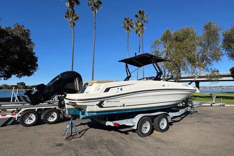 Slide: The Image of 2022 Bayliner VR6 Bowrider OB on trailer, parked near waterfront with palm trees. - 13