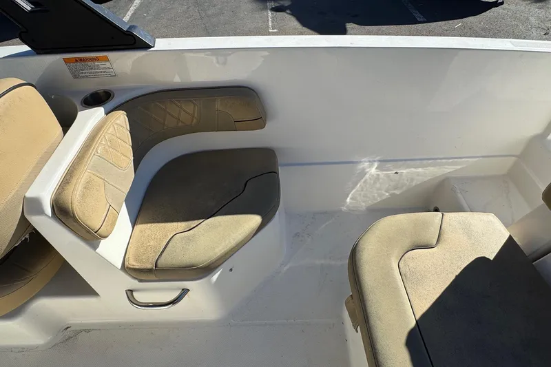 Slide: The Image of 2022 Bayliner VR6 Bowrider OB interior seating with beige cushions and cup holder. - 23