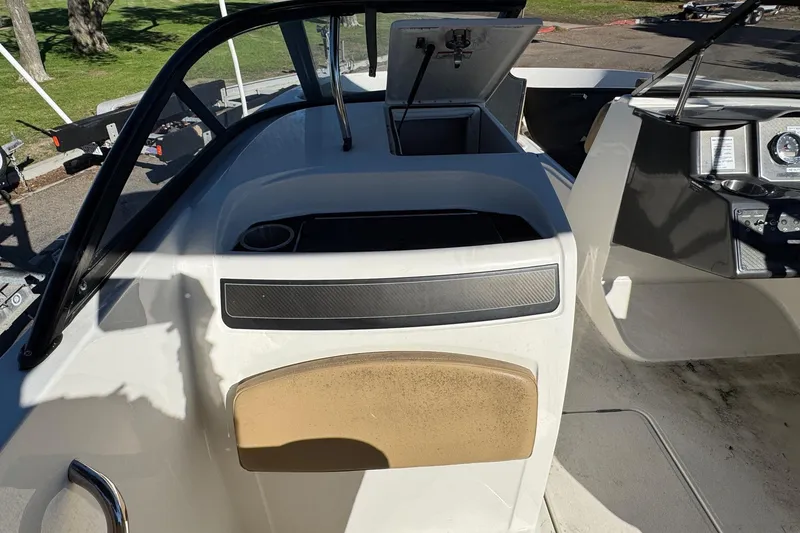 Slide: The Image of 2022 Bayliner VR6 Bowrider OB interior with open storage compartment and dashboard view. - 25