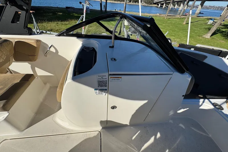 Slide: The Image of 2022 Bayliner VR6 Bowrider OB interior with seating and console, near a waterfront. - 32