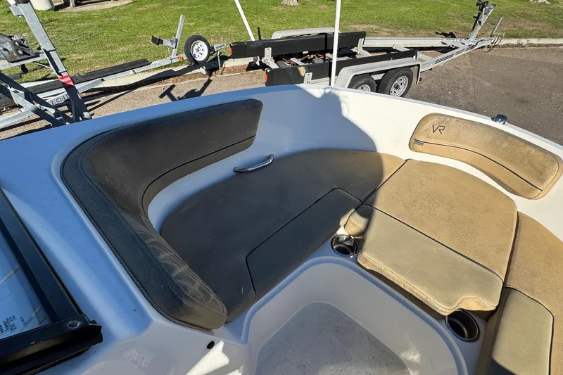 Slide: The Image of 2022 Bayliner VR6 Bowrider OB interior seating with cup holders and trailer in background. - 38