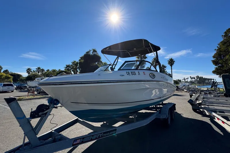 Slide: The Image of 2022 Bayliner VR6 Bowrider OB on trailer under sunny sky, parked near palm trees. - 6