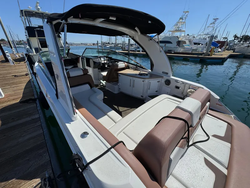 Slide: The Image of 2018 Four Winns H290 OB boat docked, featuring spacious seating and sleek design. - 10