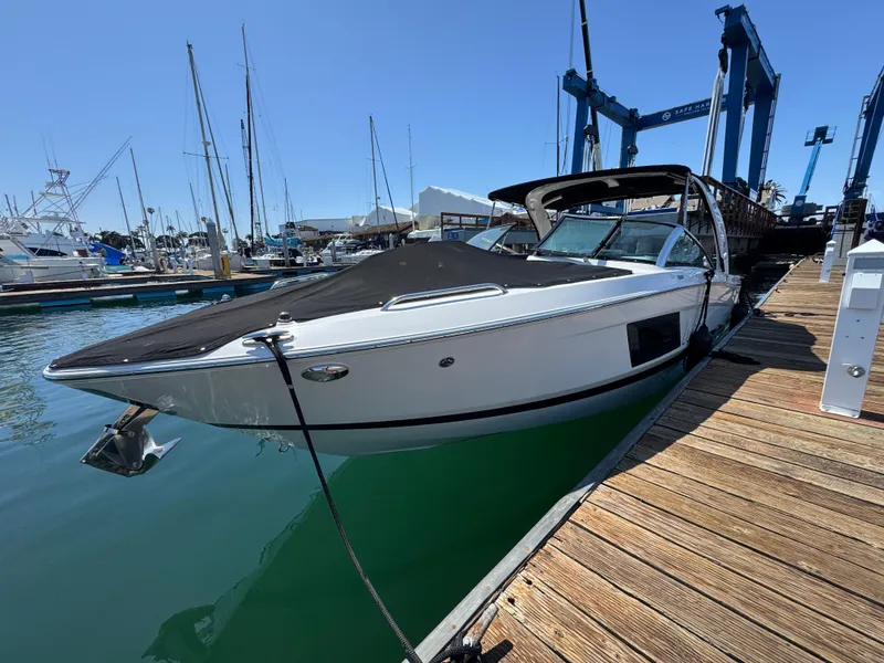 Slide: The Image of 2018 Four Winns H290 OB boat docked at a marina under clear blue skies. - 12