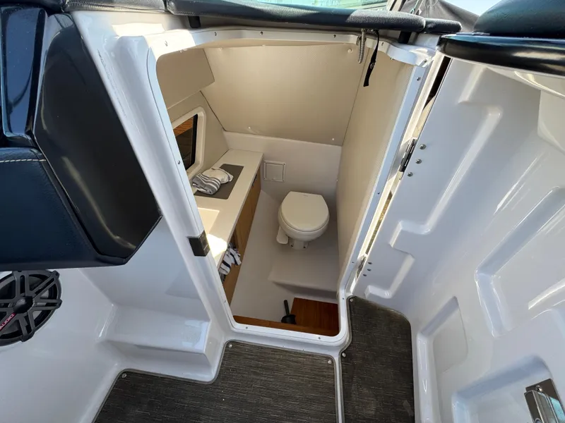 Slide: The Image of 2018 Four Winns H290 OB boat interior with compact bathroom and toilet. - 19