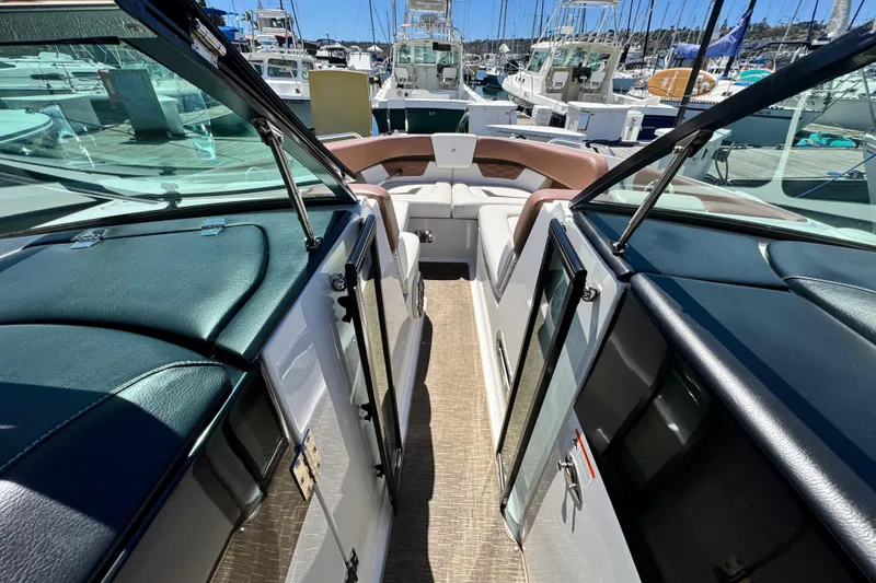 Slide: The Image of 2018 Four Winns H290 OB boat interior with seating, docked at a marina. - 20