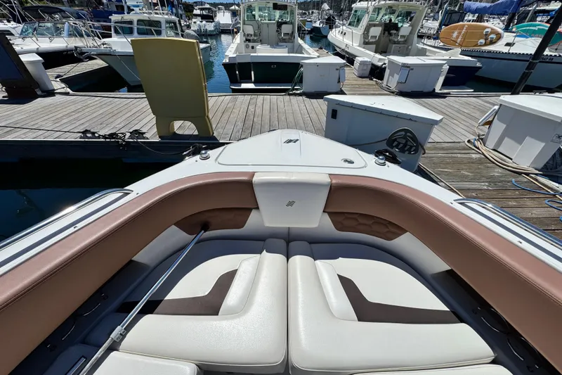 Slide: The Image of 2018 Four Winns H290 OB boat interior with cushioned seating at marina dock. - 21