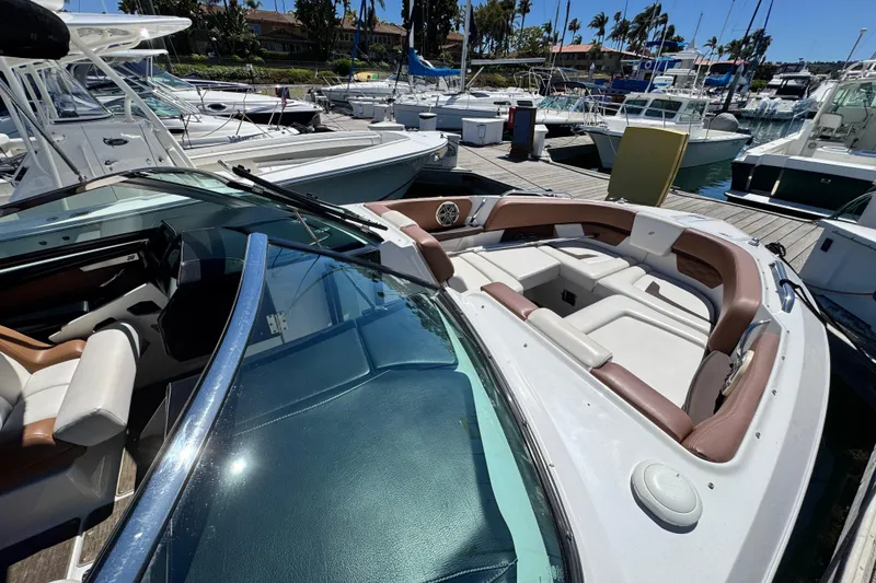 Slide: The Image of 2018 Four Winns H290 OB boat docked, featuring spacious seating and sleek design. - 23