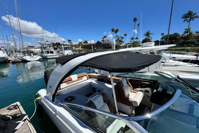 Slide: The Image of 2018 Four Winns H290 OB boat docked in a marina under a clear blue sky. - 24