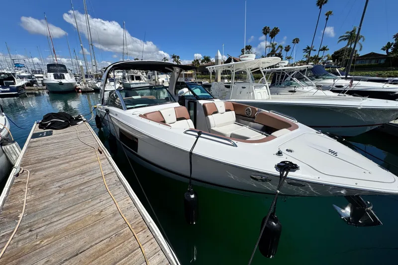 Slide: The Image of 2018 Four Winns H290 OB boat docked in a marina under a clear blue sky. - 27