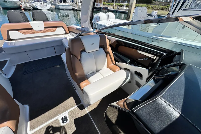 Slide: The Image of 2018 Four Winns H290 OB boat interior with luxurious seating and modern dashboard. - 28