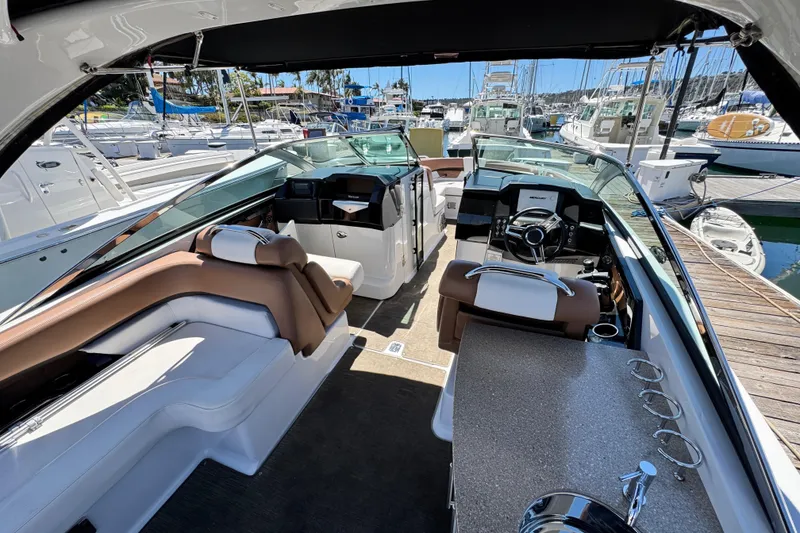Slide: The Image of 2018 Four Winns H290 OB boat interior with luxurious seating and modern dashboard at marina. - 29