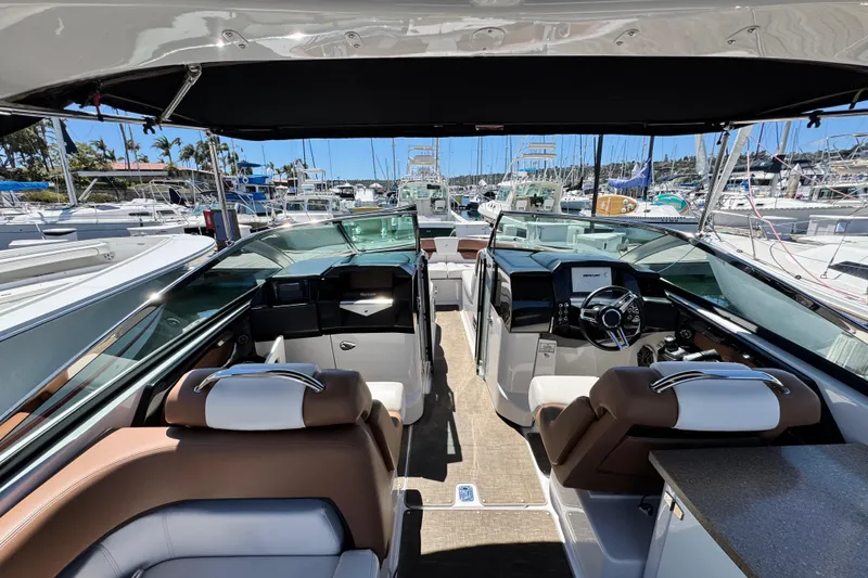 Slide: The Image of 2018 Four Winns H290 OB boat interior with luxurious seating and modern dashboard at a marina. - 30