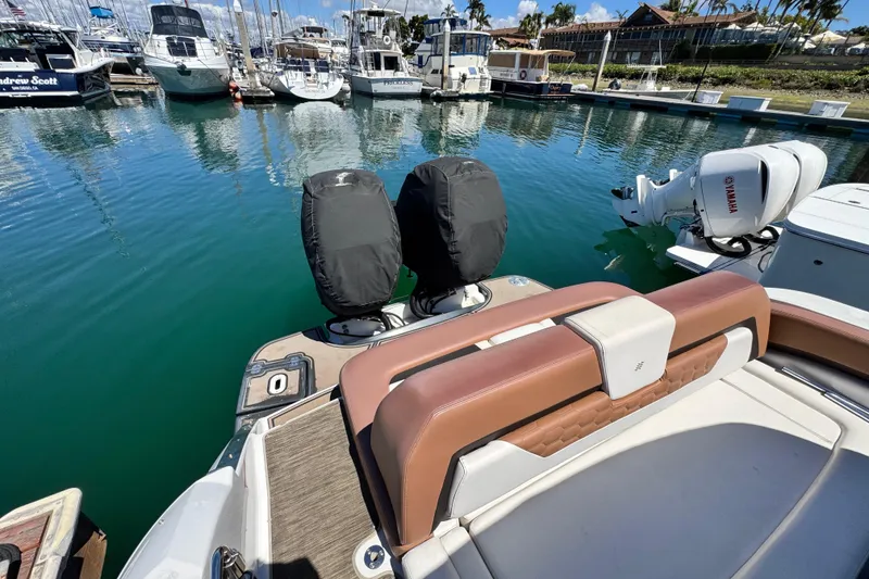 Slide: The Image of 2018 Four Winns H290 OB boat with dual outboard engines docked in a marina. - 35