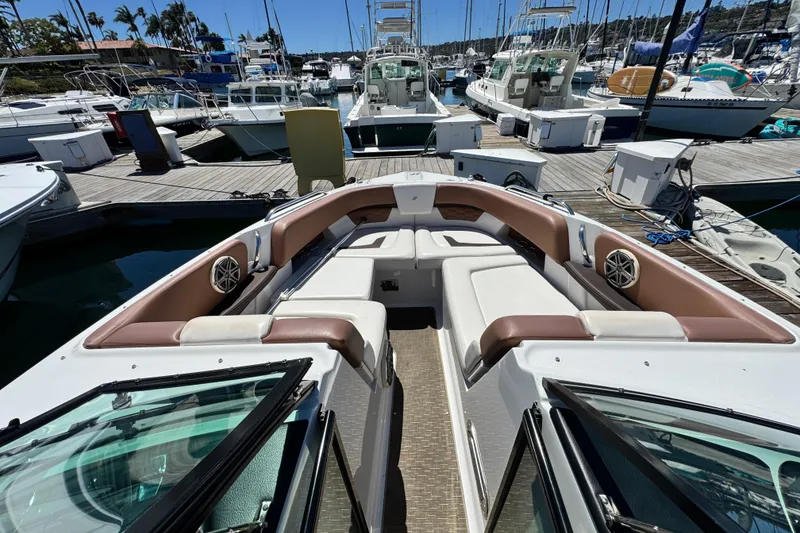 Slide: The Image of 2018 Four Winns H290 OB boat docked at marina, featuring spacious seating and modern design. - 40