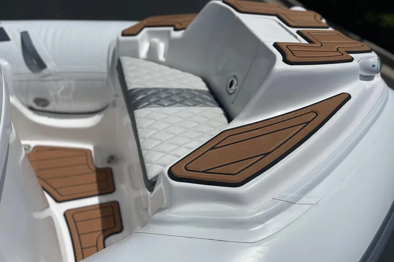 Slide: The Image of 2025 Caribe DL11 boat interior with white quilted seating and brown accents. - 16