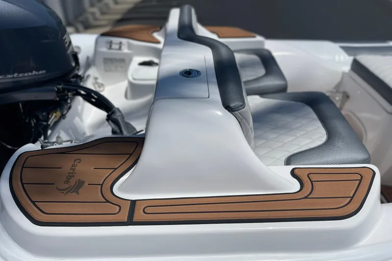 Slide: The Image of 2025 Caribe DL11 boat interior with cushioned seating and wood accents. - 19