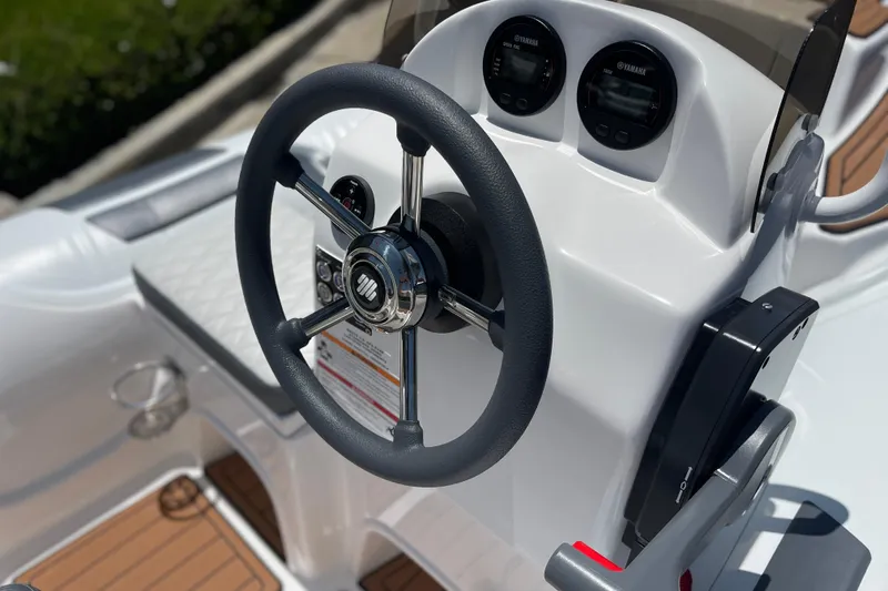 Slide: The Image of Steering console of 2025 Caribe DL11 boat with modern controls and gauges. - 22