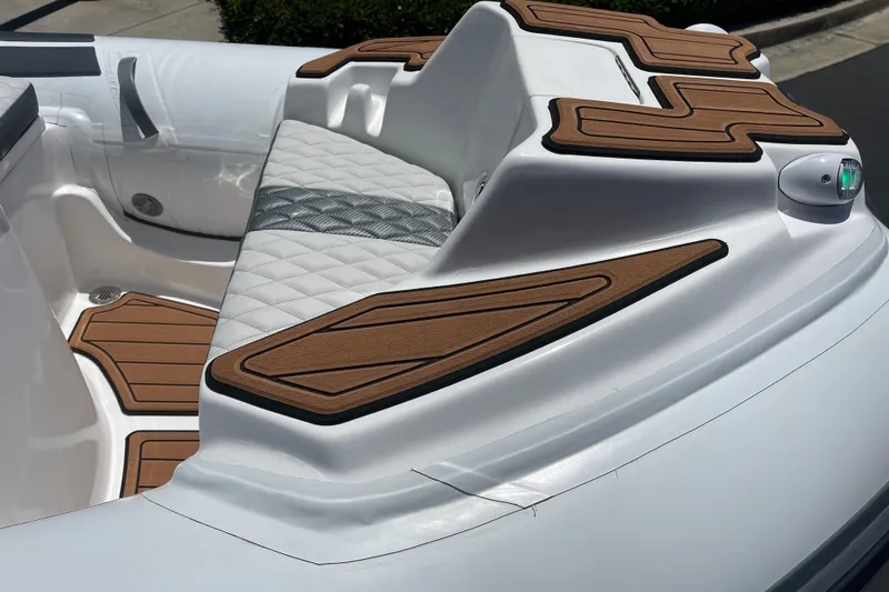 Slide: The Image of 2025 Caribe DL11 boat interior with cushioned seating and wood accents. - 24