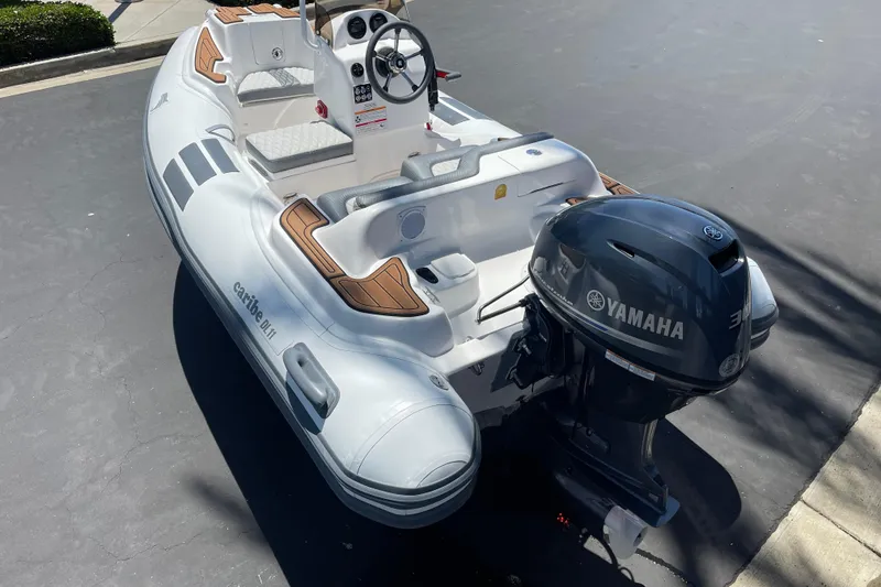 Slide: The Image of Inflatable Caribe DL11 boat, 2025 model, with Yamaha outboard motor, parked on pavement. - 32