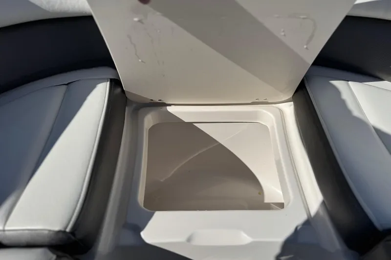 Slide: The Image of 2017 Chaparral 2870 SSX boat storage compartment with open lid, featuring cushioned seating. - 20