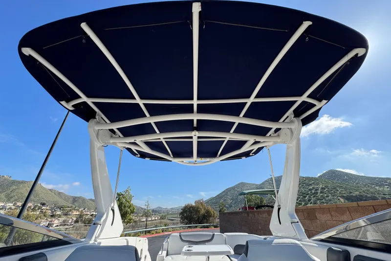 Slide: The Image of 2017 Chaparral 2870 SSX boat with canopy, scenic mountain backdrop, clear blue sky. - 22