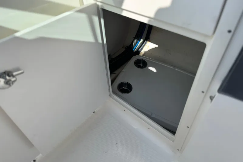 Slide: The Image of Open storage compartment in 2017 Chaparral 2870 SSX boat, featuring cup holders. - 39