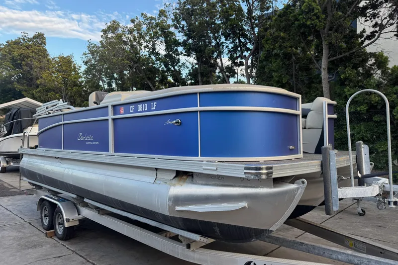 The Image of 2023 Barletta ARIA 22QC pontoon boat on trailer, parked outdoors. - 0