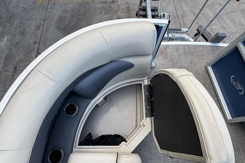 Slide: The Image of 2023 Barletta ARIA 22QC boat interior with cushioned seating and storage compartment. - 24