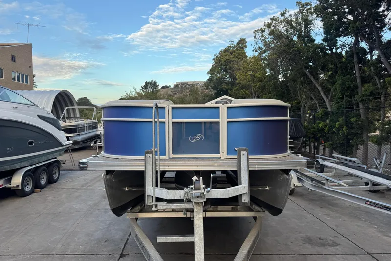 Slide: The Image of 2023 Barletta ARIA 22QC pontoon boat on trailer, parked outdoors. - 4