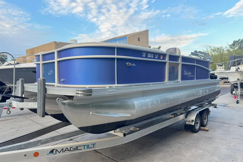 Slide: The Image of 2023 Barletta ARIA 22QC pontoon boat on trailer, blue and silver design. - 6