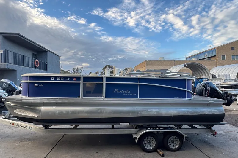 Slide: The Image of 2023 Barletta ARIA 22QC pontoon boat on trailer under a partly cloudy sky. - 9