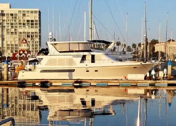 The Image of 1993 Tollycraft 57 Pilothouse yacht docked in marina with buildings. - 0