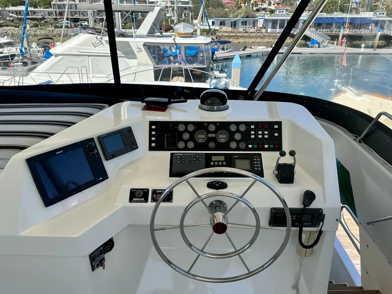 Slide: The Image of 1993 Tollycraft 57 Pilothouse yacht helm station in marina. - 22