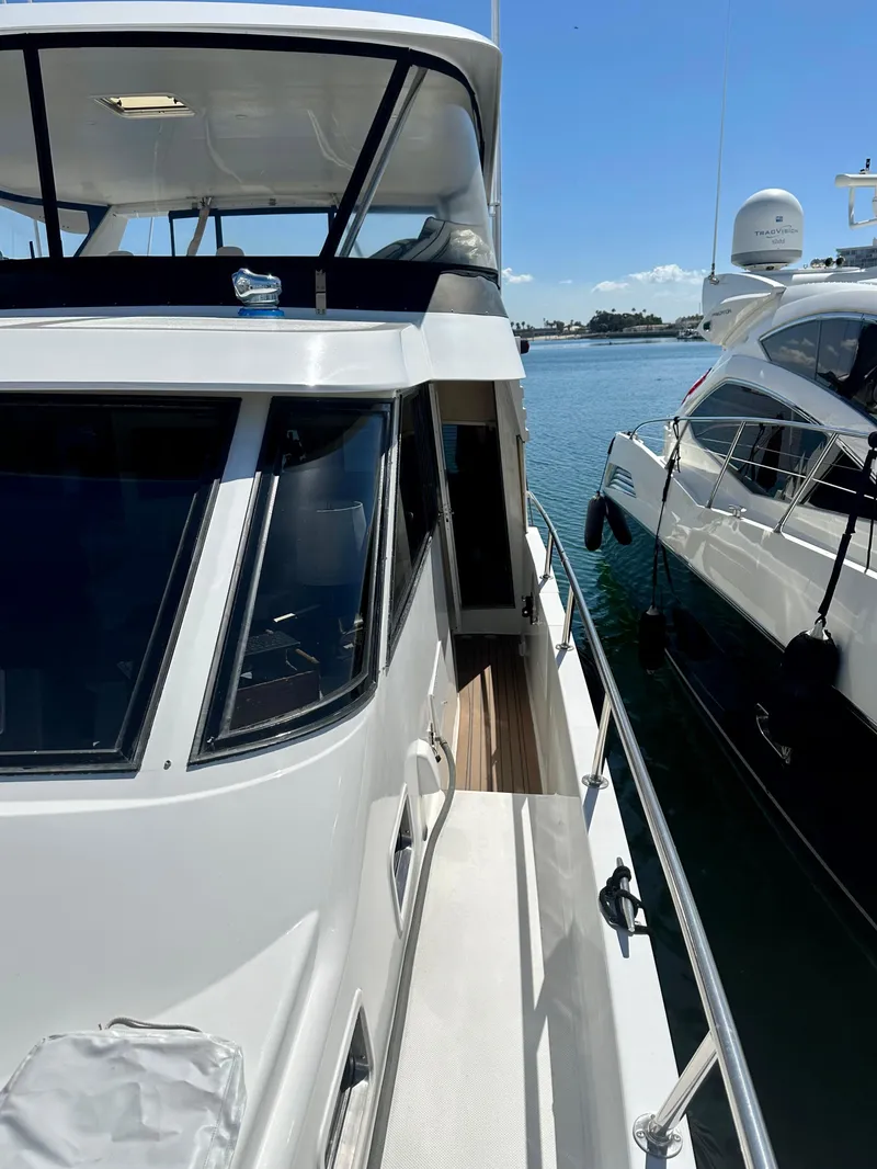 Slide: The Image of 1993 Tollycraft 57 Pilothouse yacht docked by water. - 32